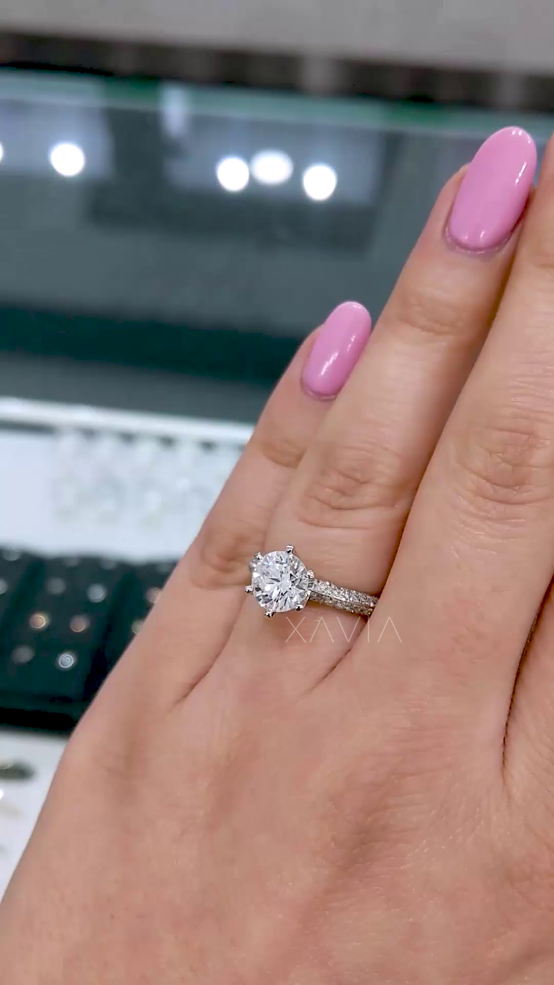 Top view of round brilliant solitaire engagement ring with pavé band and six-prong setting, crafted in white gold